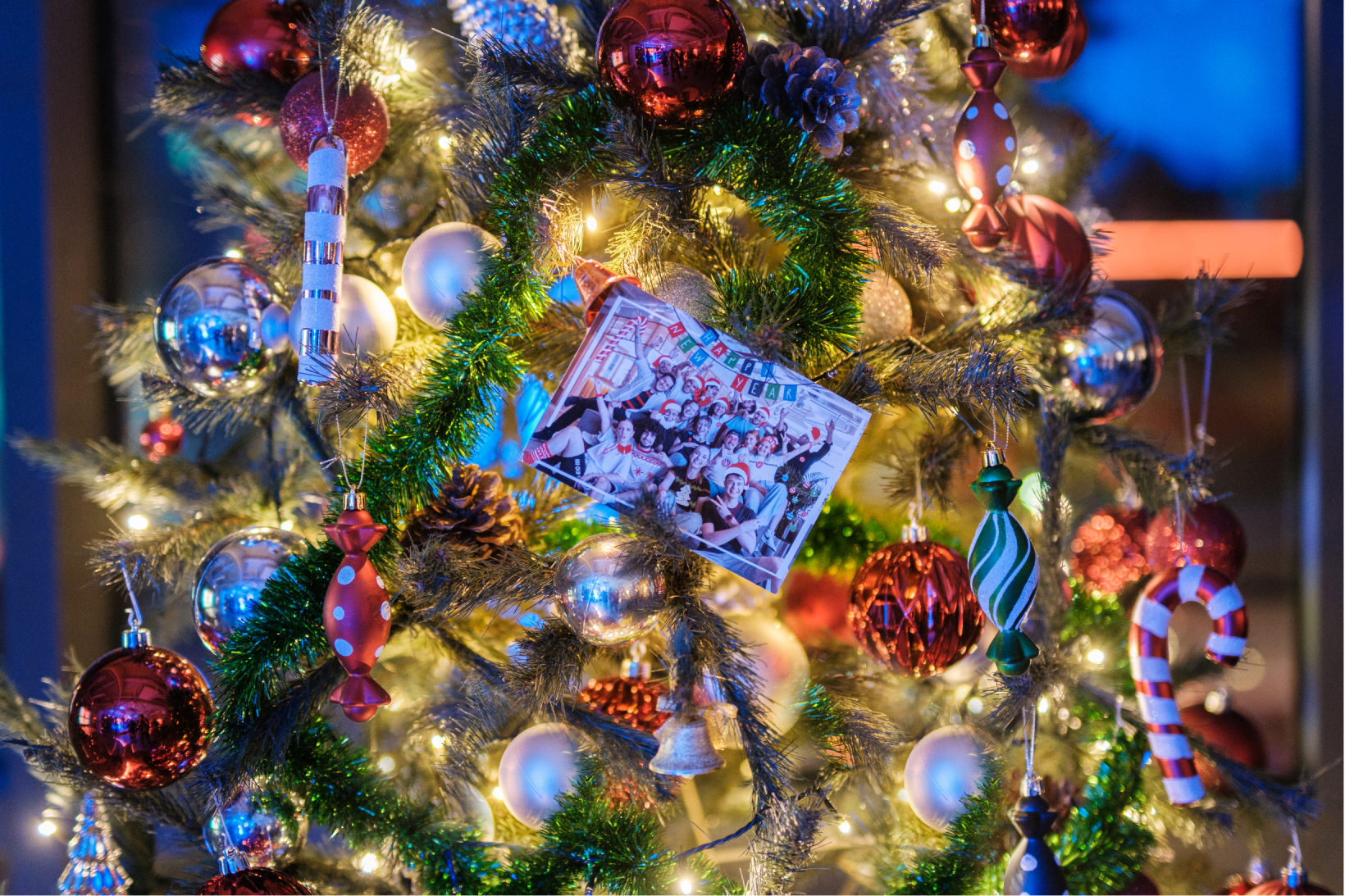 A “Happy New Year” card with Atolye15 employees on a Christmas tree with yellow lights and red and gold ornaments.