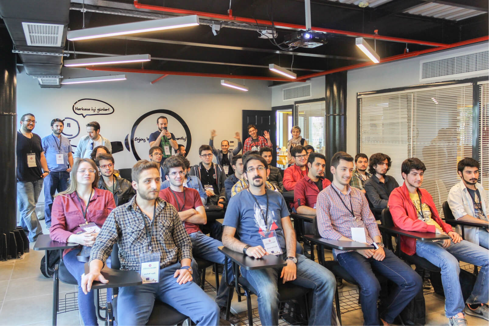 A group of people sitting in a small conference room wearing name tags.