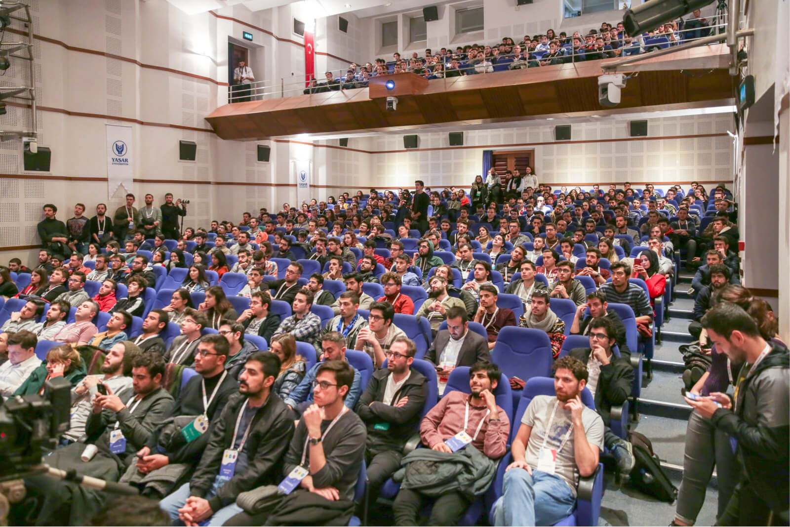 A large crowd of people sitting in a conference hall listening to a presentation at Atolye15’s WTK’18.