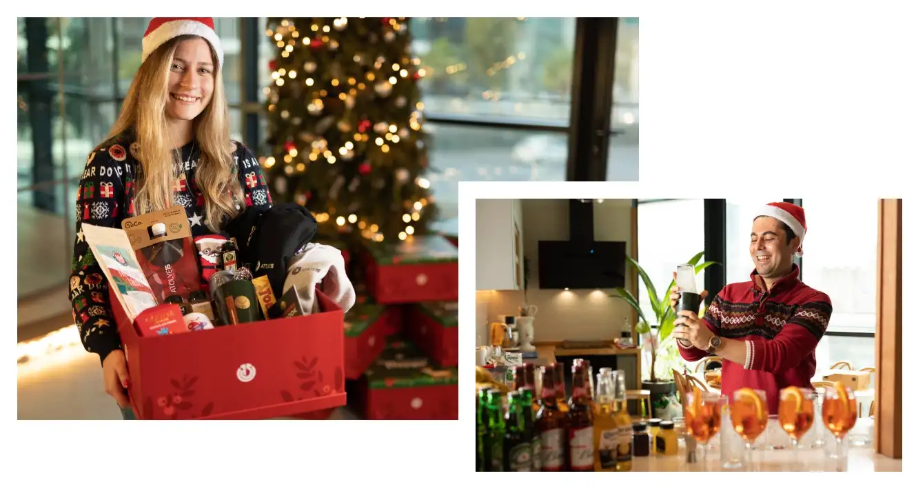 A young blond girl holding the Atolye15 New Year kit filled with gifts and a man in a Santa hat making cocktails.