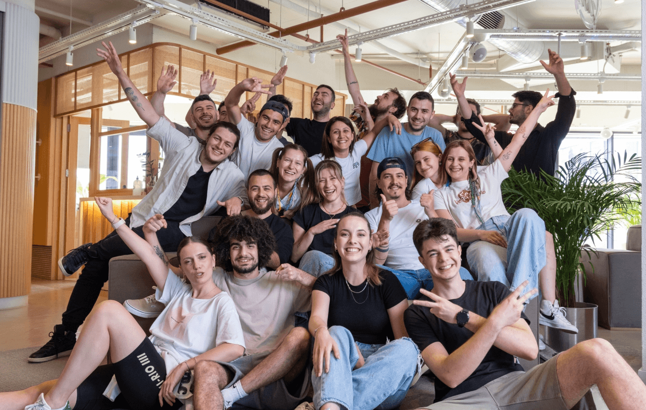 A happy group of coworkers with fun and playful gestures in a bright office.