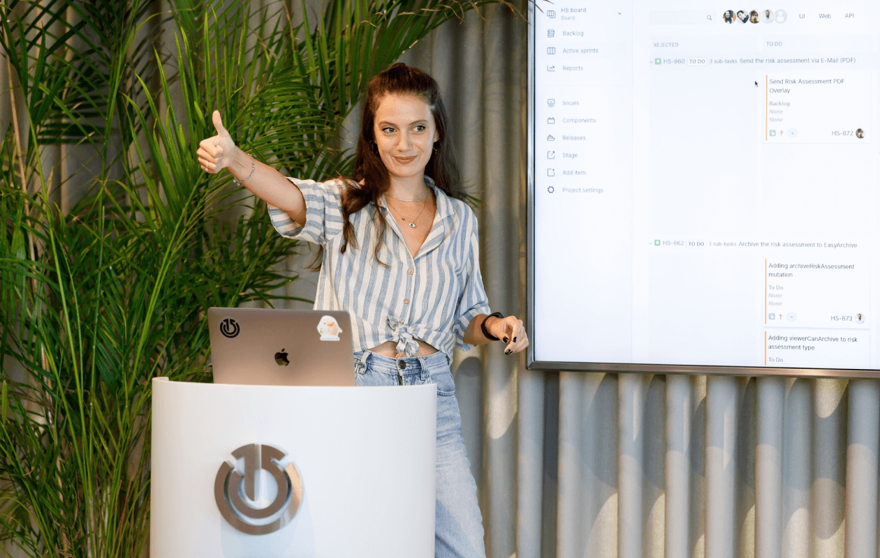 Woman giving a thumbs up beside a laptop with Atolye15 logo, project screen in view.