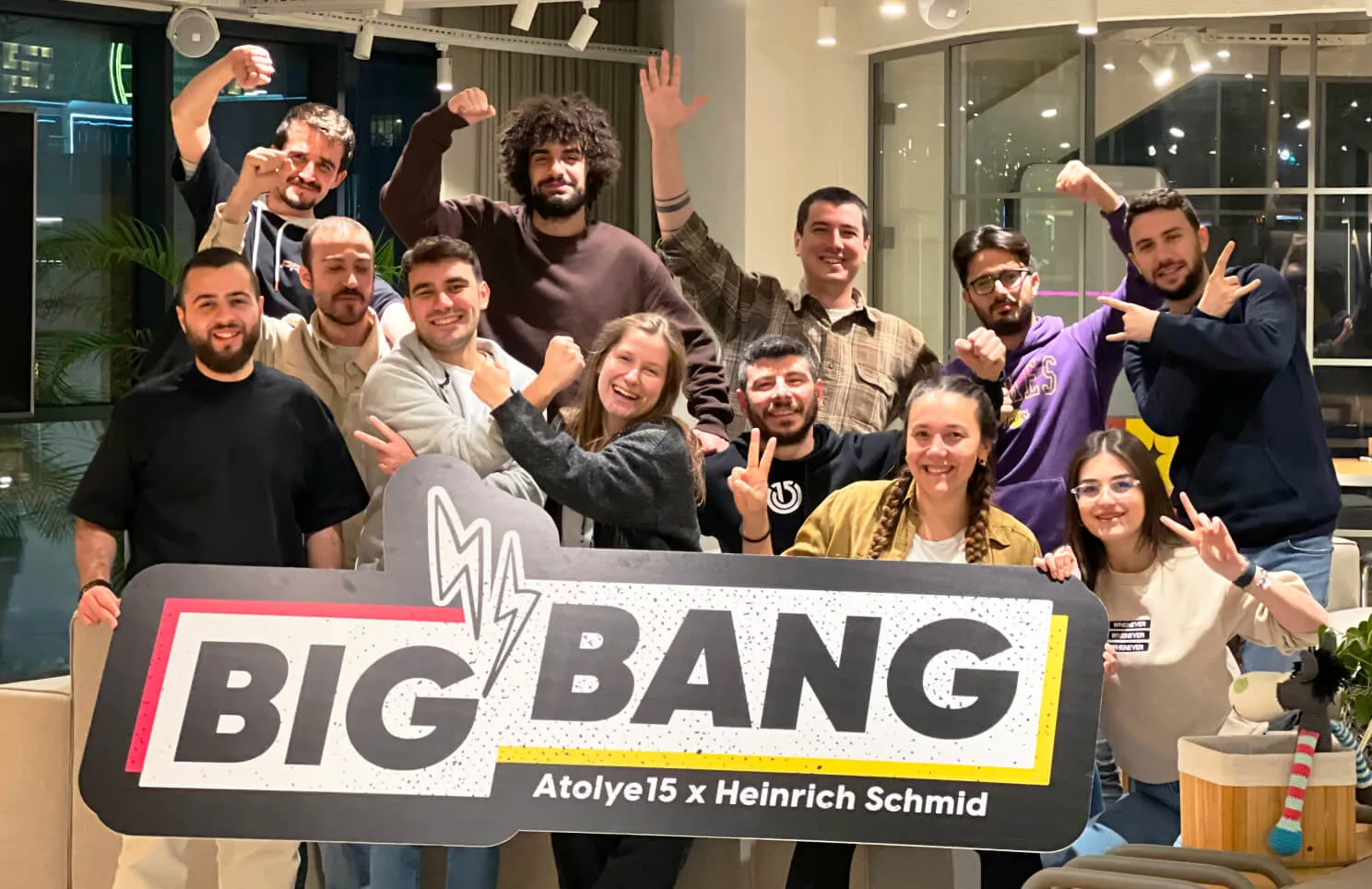 Group photo of a team at an event with a 'BIG BANG' sign with Atolye15 and Heinrich Schmid written underneath.