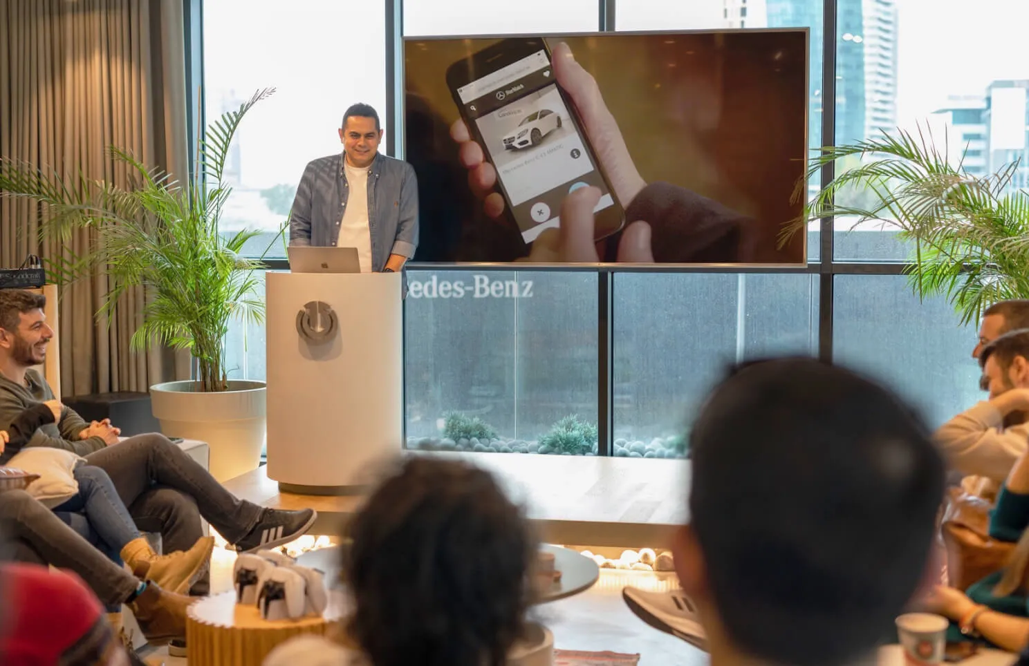 Man giving a presentation showing a StarMatch’s mobile app screen, audience in foreground.