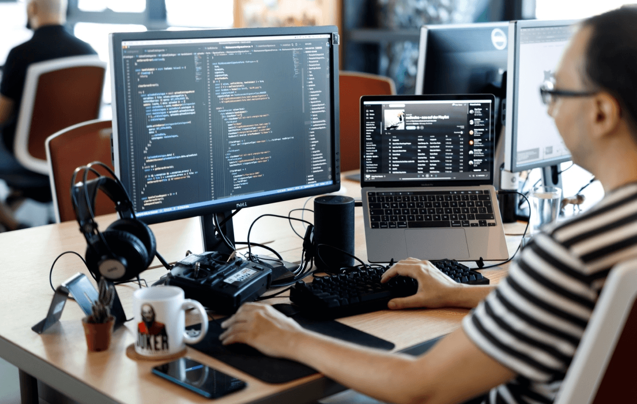 A developer's workstation with dual screens showing code.