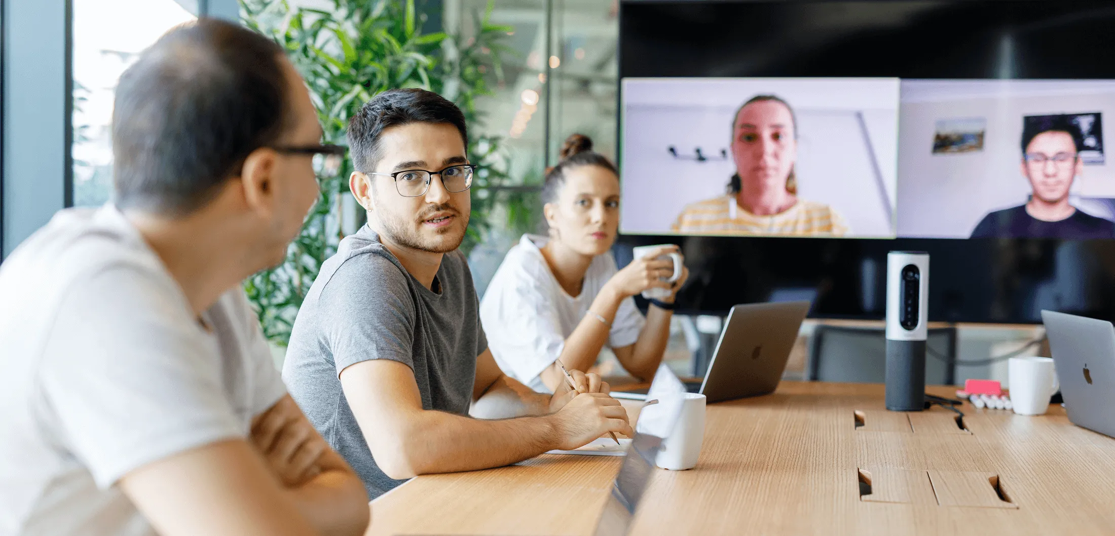 A group of five people chatting and laughing in a modern office.