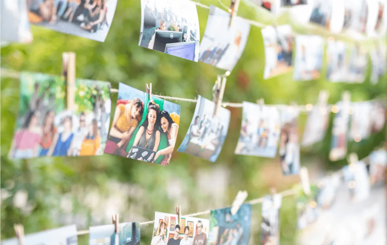 Printed team photos hanging on a string outdoors, capturing Atolye15 memories together.